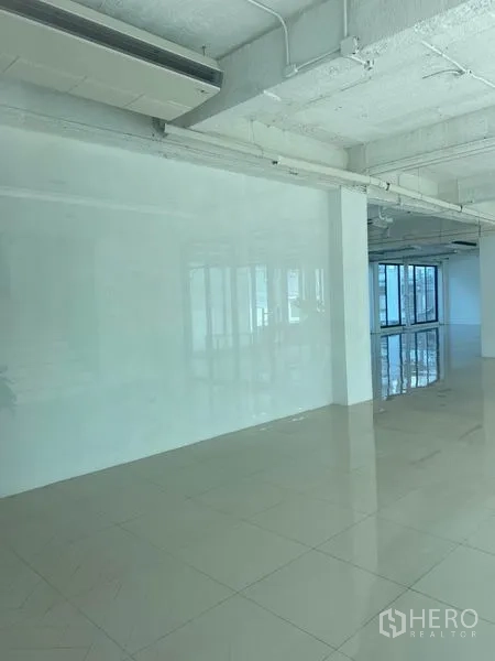 办公空间 出租在Khlong Toei, Bangkok - 纯白办公室内部，外露天花与壁挂空调，光亮瓷砖地面。