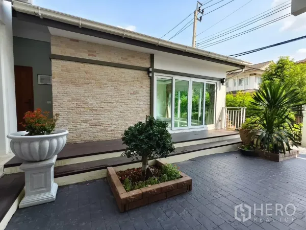 Detached House for rent in Bang Kapi, Bangkok - Front patio with raised deck, sliding glass doors and stone-clad wall.