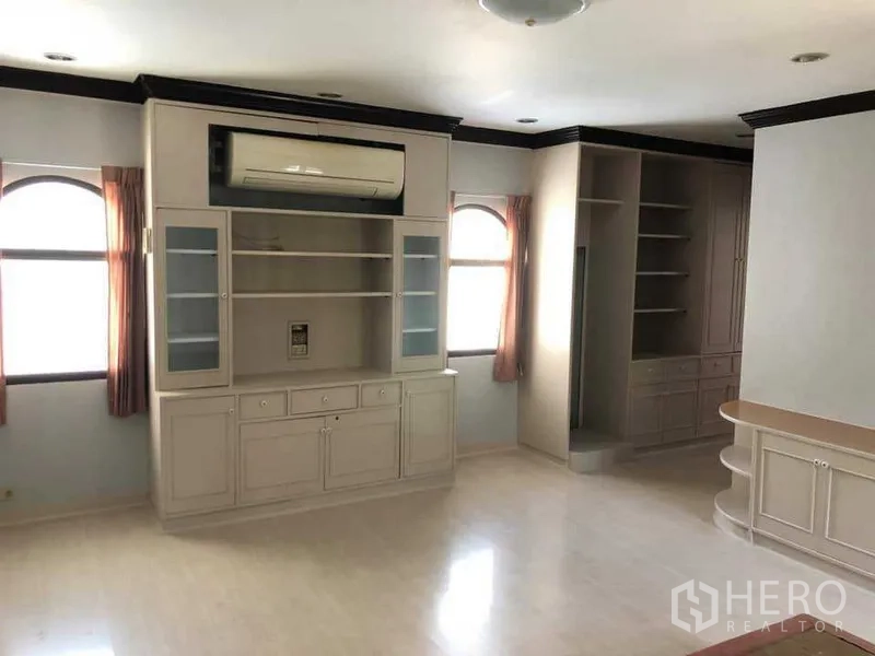 Detached House for rent in Phra Khanong, Bangkok - Upper‑floor family room with built‑in cabinets, shelving and air conditioner.