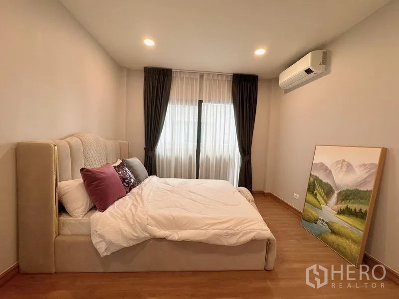 Detached House for rent or sale in Bang Phli, Samut Prakan - Warm bedroom with upholstered bed, air-conditioning and blackout curtains.