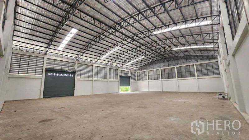 โรงงาน ให้เช่าในBan Phaeo, Samut Sakhon - ภายในโรงงานโปร่งโล่ง หลังคาโค้งโครงเหล็ก มีช่องแสงสกายไลท์ ช่องลม และประตูม้วนขนาดใหญ่