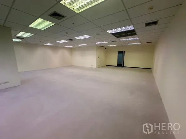 Office Space for rent in Bang Na, Bangkok - Large empty office room with suspended ceiling, air vents, and doorway to a service corridor.