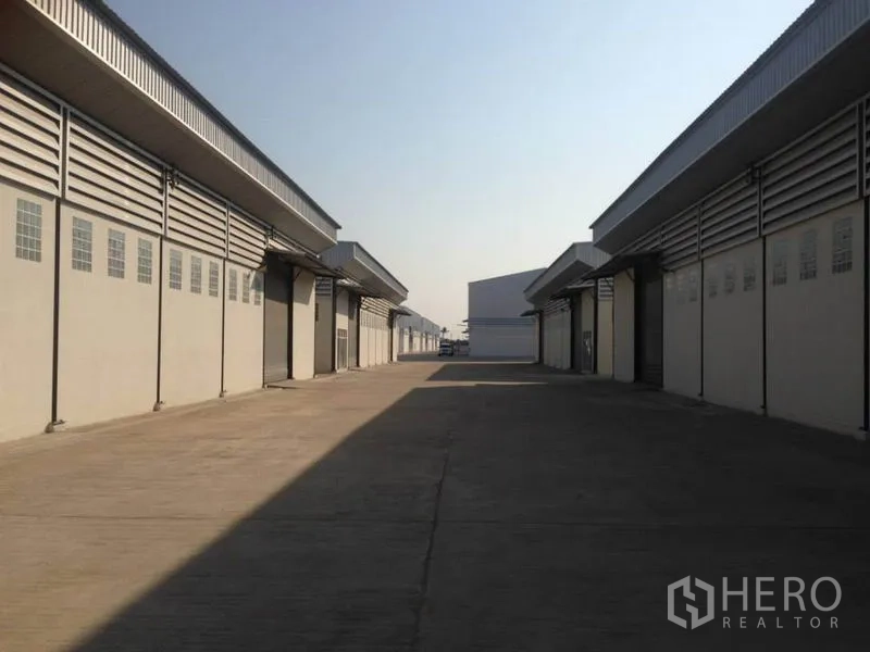 货栈 出租在Bang Bua Thong, Nonthaburi - 邦武通现代仓库区之间的宽阔混凝土车道与卷闸装卸口