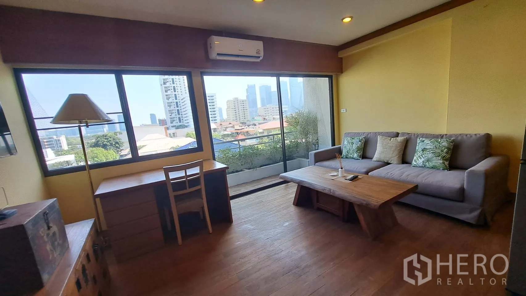 คอนโด for rent in Khlong Toei, Bangkok - ห้องนั่งเล่นสว่างด้วยหน้าต่างบานใหญ่ โต๊ะทำงาน โซฟา และประตูบานเลื่อนออกระเบียงวิวเมือง