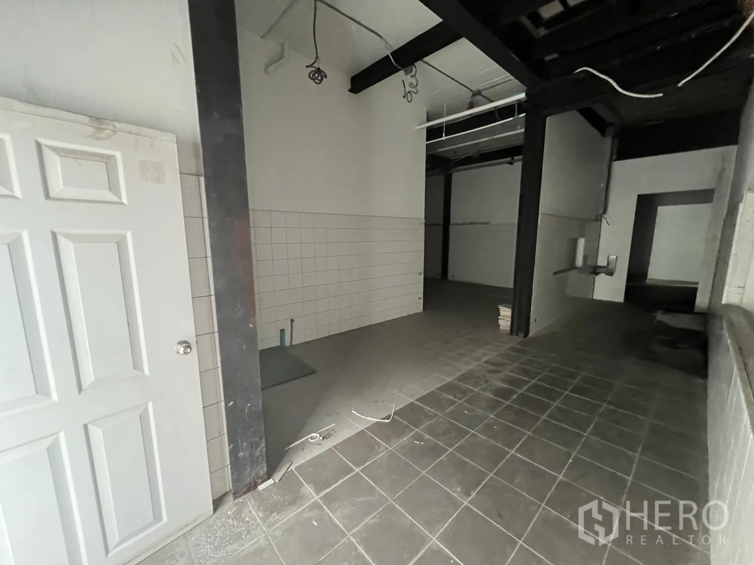 Retail Space for rent in Watthana, Bangkok - Back-of-house tiled area with steel beams and plumbing points.