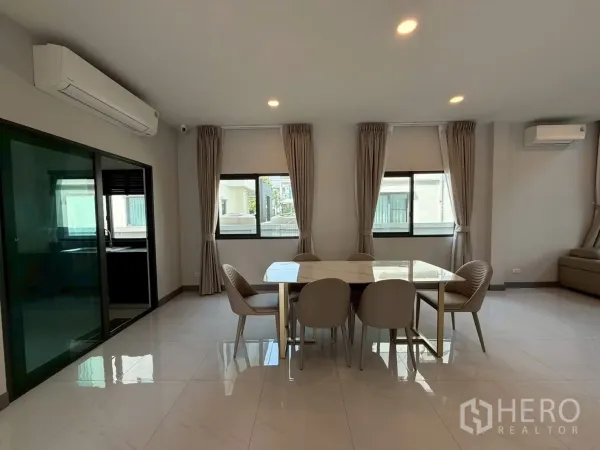 Townhouse for rent - Open‑plan dining space with sliding glass door to the kitchen and recessed ceiling lights.