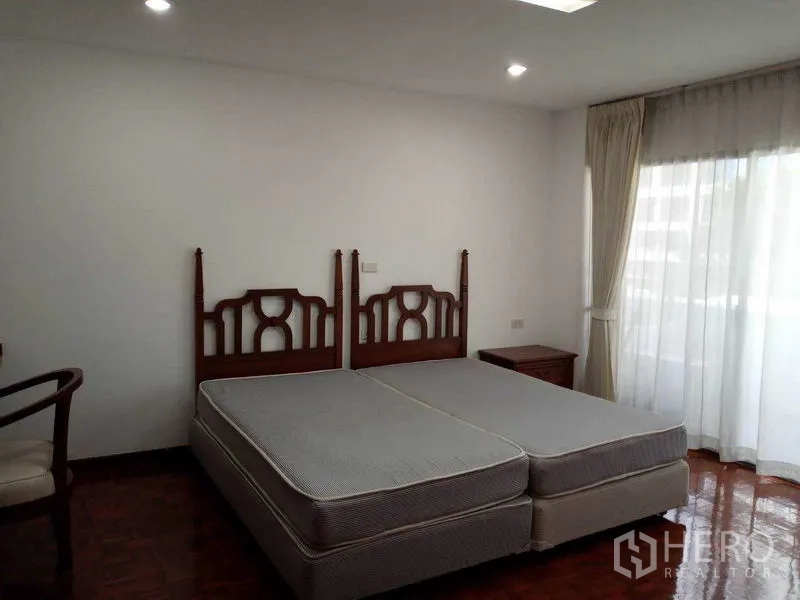 公寓 出租在Watthana, Bangkok - 次卧配双床，木质床头，大窗配纱帘