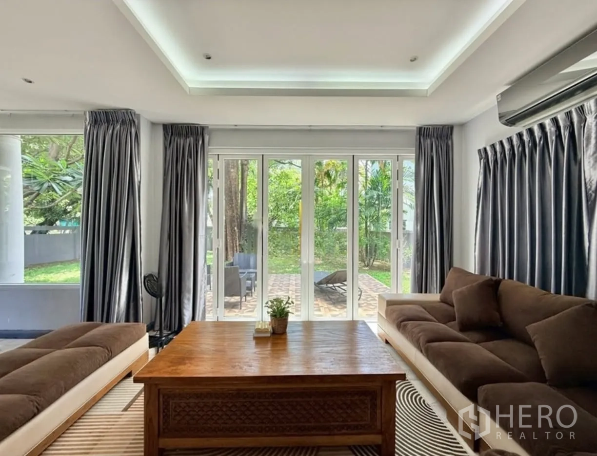 Detached House for rent in Phra Khanong, Bangkok - Living room with sliding glass doors opening to the garden patio.