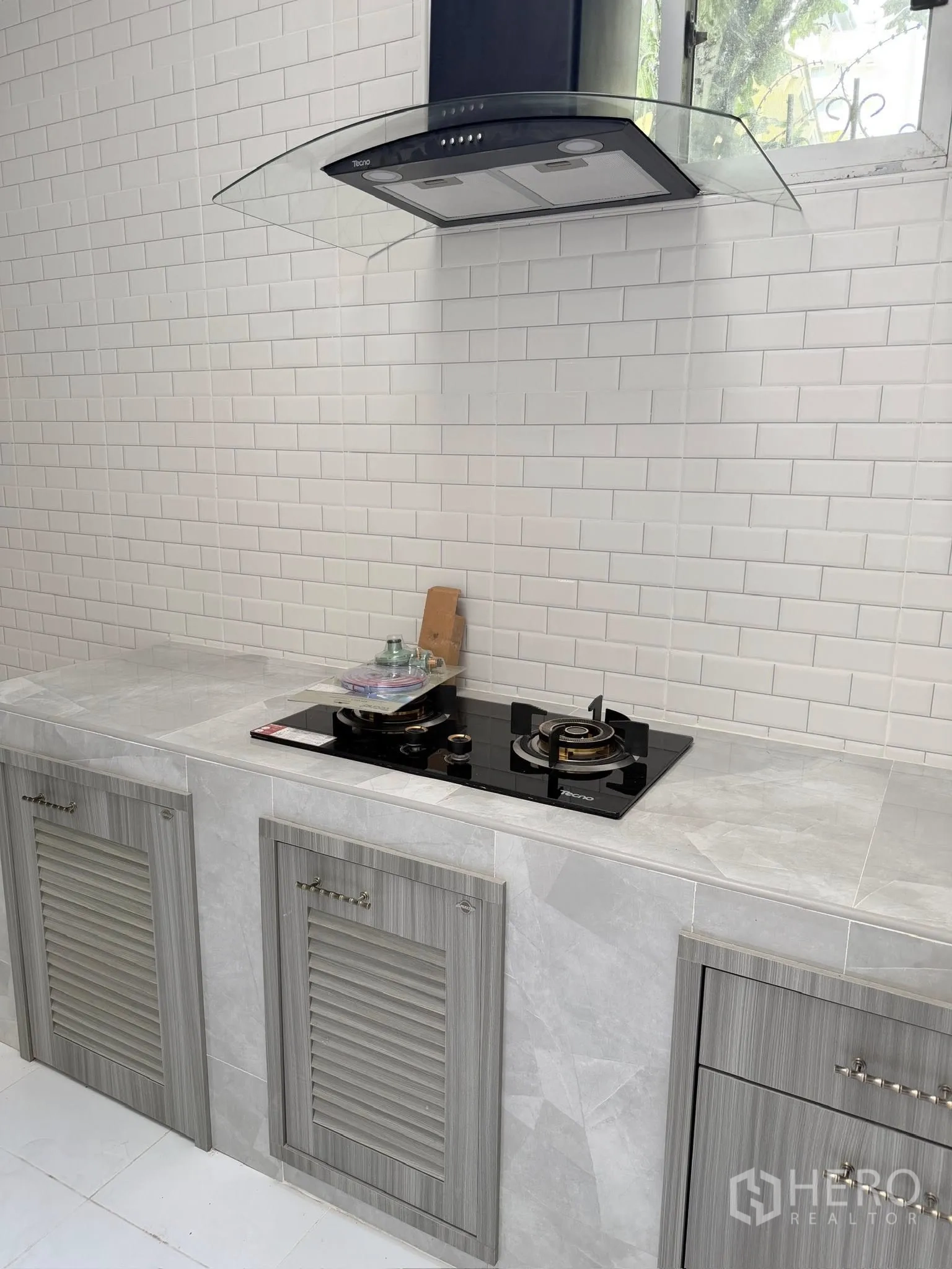 Townhouse for rent or sale in Yan Nawa, Bangkok - Close-up of cooktop with range hood beneath a small window.