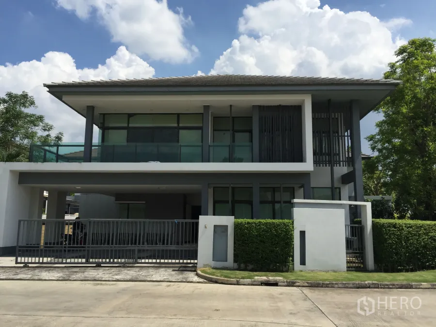 Detached House for rent or sale in Bang Kapi, Bangkok - Modern two-storey detached house with balcony, gated carport and neat hedges in a private estate.