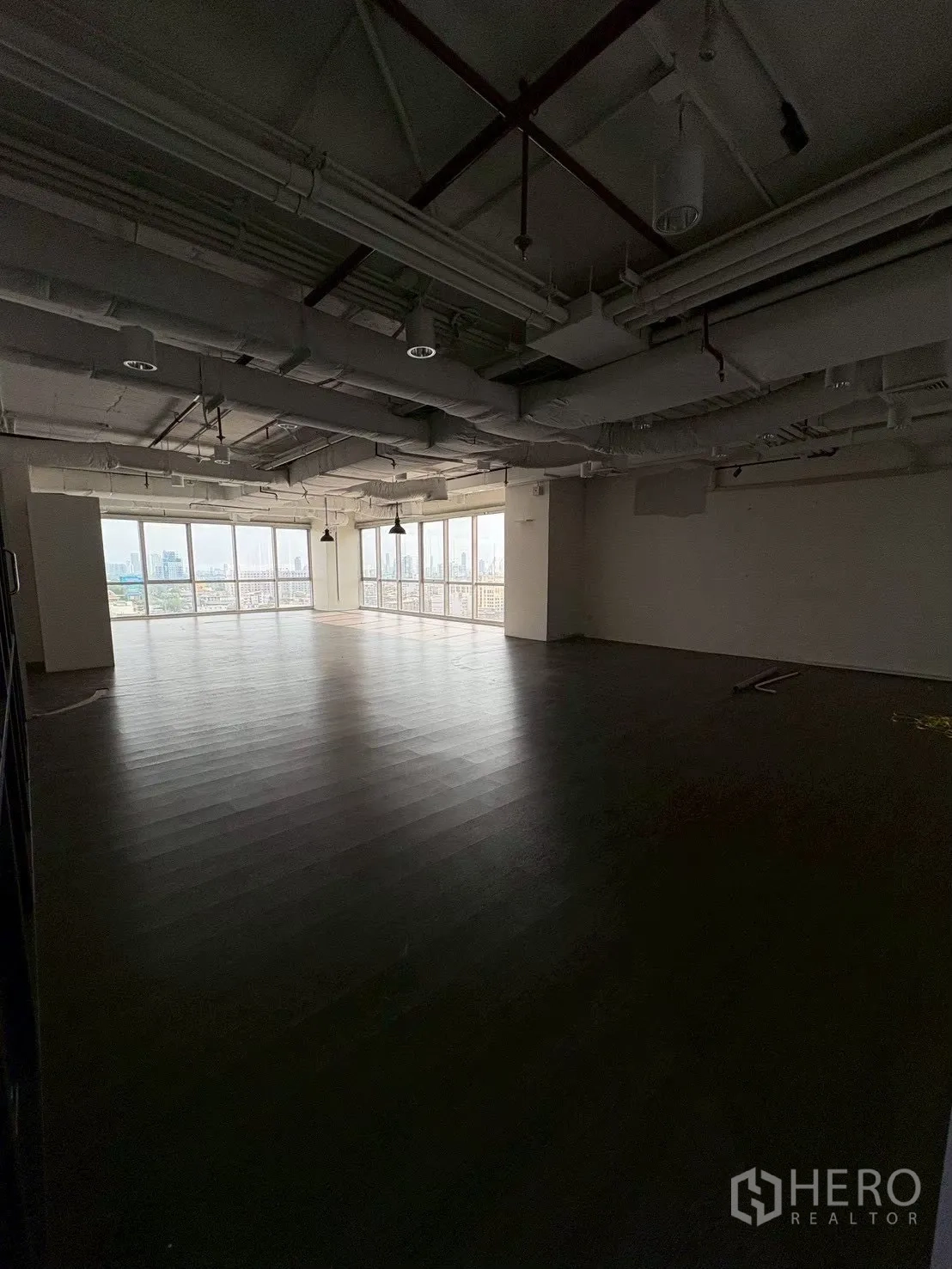 Office Space for rent in Khlong Toei, Bangkok - Large open-plan workspace with dark flooring and an exposed ceiling.