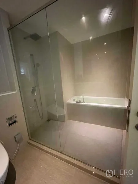 Condominium for rent in Watthana, Bangkok - Spa-style wet room featuring a rain shower and separate built-in bathtub behind a clear glass partition.