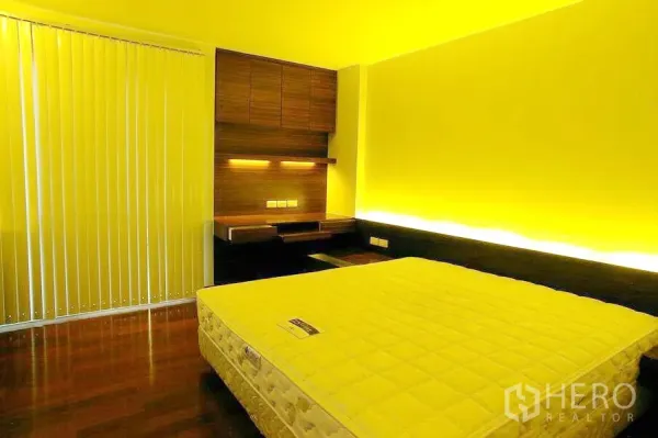 公寓 出租在Watthana, Bangkok - 卧室配有内置书桌与柜体，床头氛围灯、竖百叶与木地板。