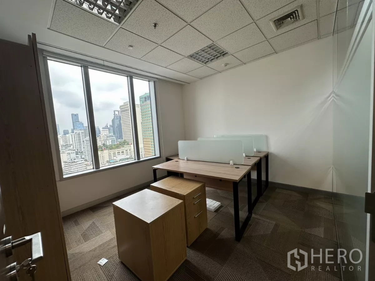 Office Space for rent in Watthana, Bangkok - Compact office with two workstations and glass partitions overlooking the skyline.