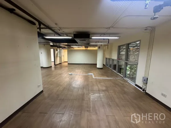 货栈 出租 - 宽敞弹性空间，侧面长窗，天花管道与木色地面。