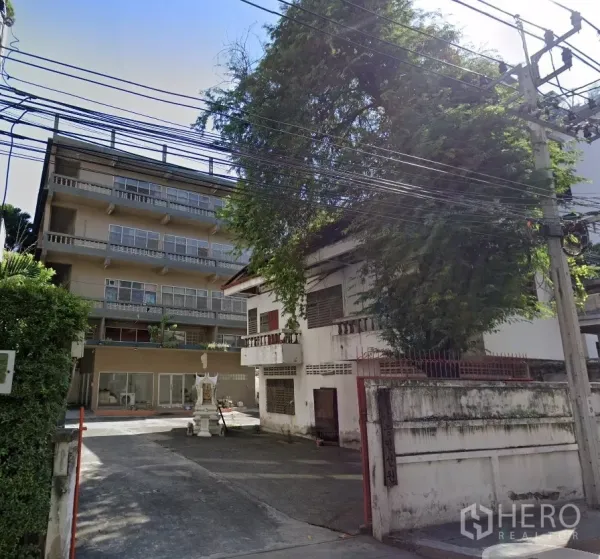 Office Space for rent - Gated entrance leading to four-storey office building with courtyard and mature tree