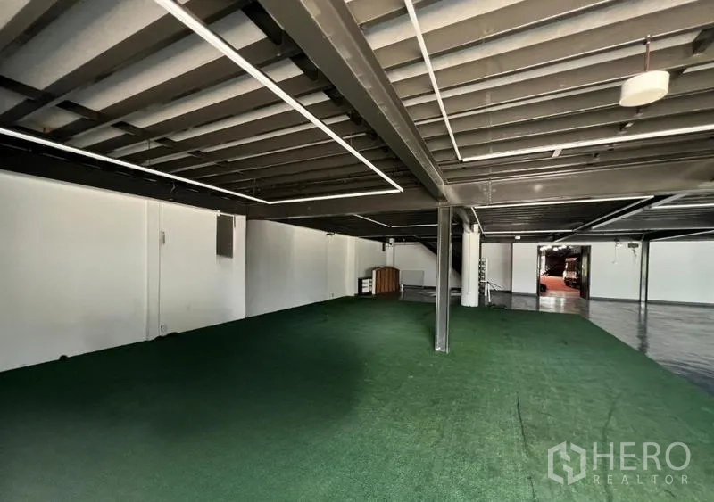 Showroom for rent in Mueang Samut Prakan, Samut Prakan - Covered mezzanine zone with green turf flooring beneath steel framing