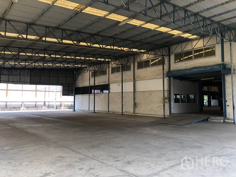 Factory for rent in Sai Noi, Nonthaburi - Covered warehouse area with open concrete floor and ample vehicle turning space.