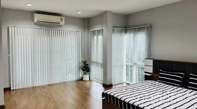 Detached House for rent in Lam Luk Ka, Pathum Thani - Large master bedroom with floor-to-ceiling blinds and corner windows.