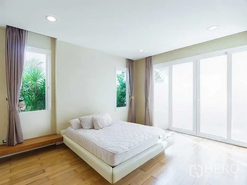 Detached House for rent or sale in Bang Phli, Samut Prakan - Minimalist bedroom with platform bed, wood flooring and tall windows