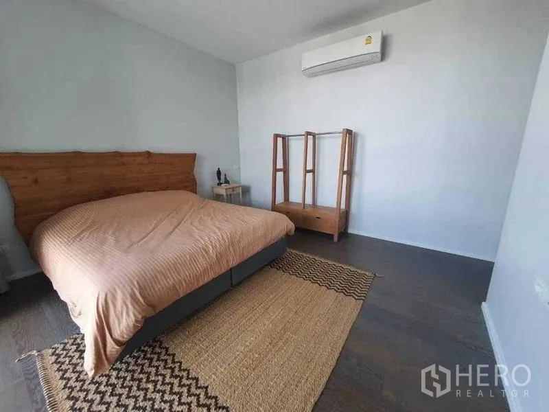 独立式住宅 出租或出售在Prawet, Bangkok - 极简卧室，床、空调与编织地毯。