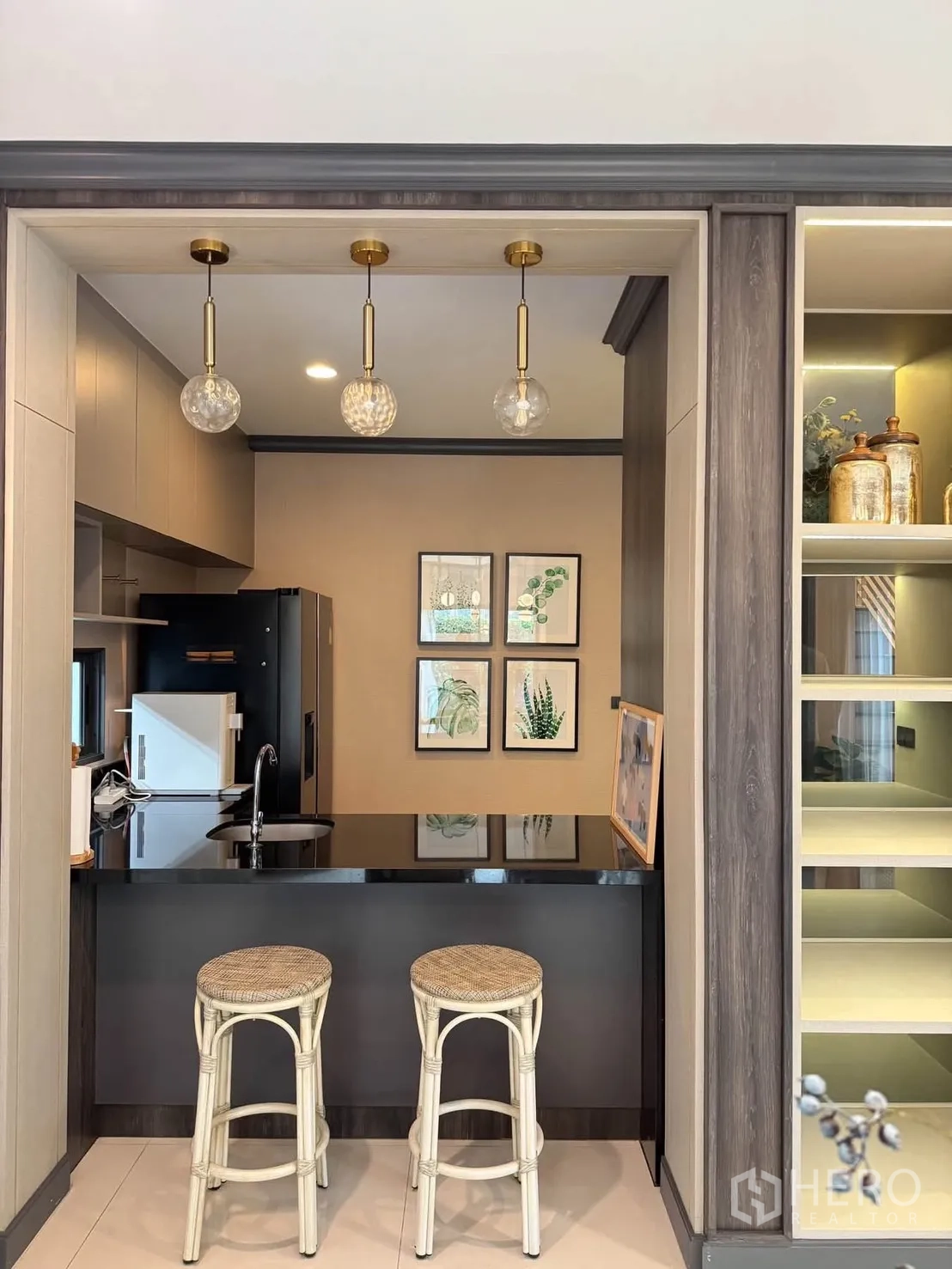 Detached House for rent in Bang Kapi, Bangkok - Breakfast bar kitchen with black countertop, sink, three pendant lights, and two stools.