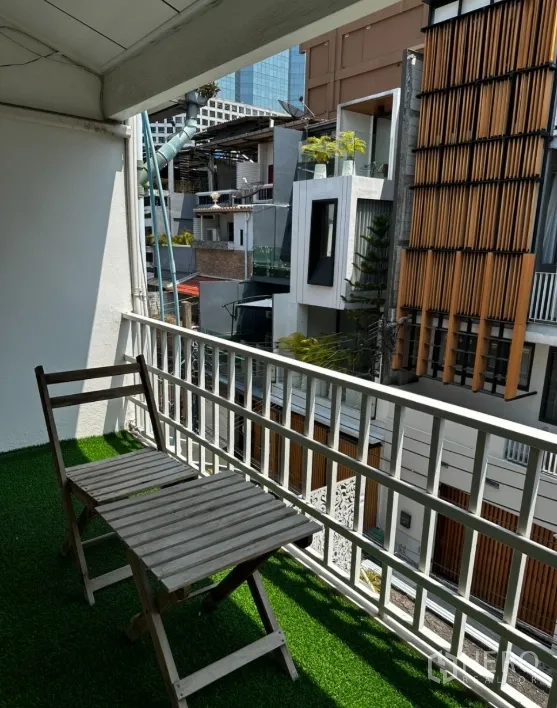 联排别墅 for rent in Sathon, Bangkok - 阳台铺人造草，配折叠椅，眺望城市街景。