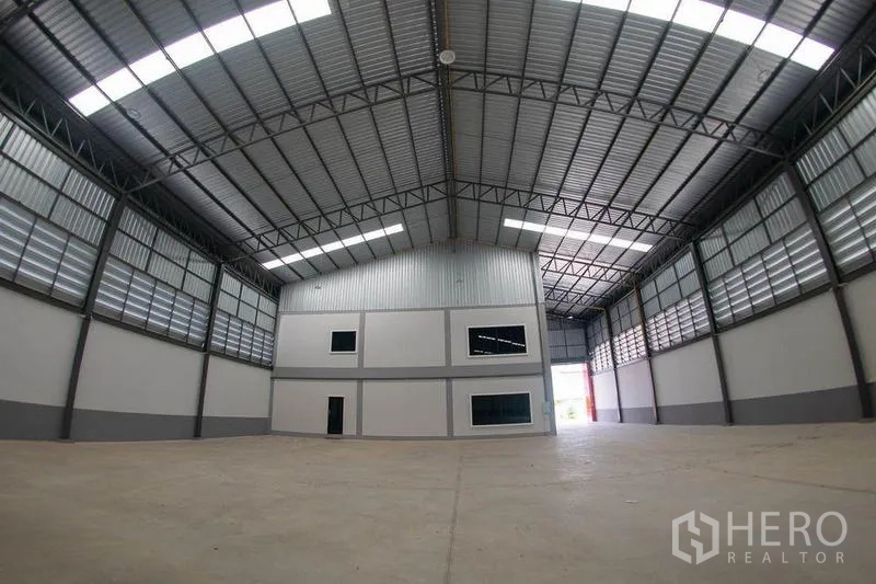 Warehouse for sale in Krathum Baen, Samut Sakhon - Warehouse interior facing a built-in two-storey office block and loading exit.