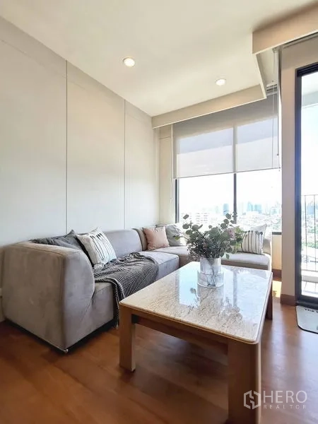 Condominium for rent in Sathon, Bangkok - Living area next to the balcony with marble coffee table and skyline views.