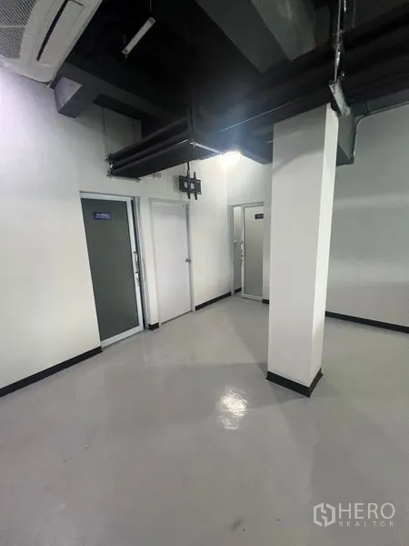 พื้นที่ขายปลีก ให้เช่าในWatthana, Bangkok - โซนบริการพร้อมประตูหลายบานสำหรับเก็บของหรือห้องพนักงาน ใต้ท่อดักท์ลมเปลือย