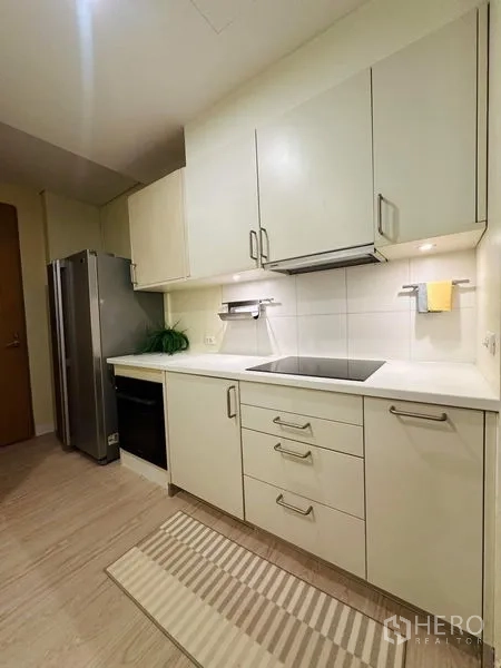 Condominium for rent in Bang Rak, Bangkok - Kitchen angle showing large refrigerator, oven, and generous countertop space.