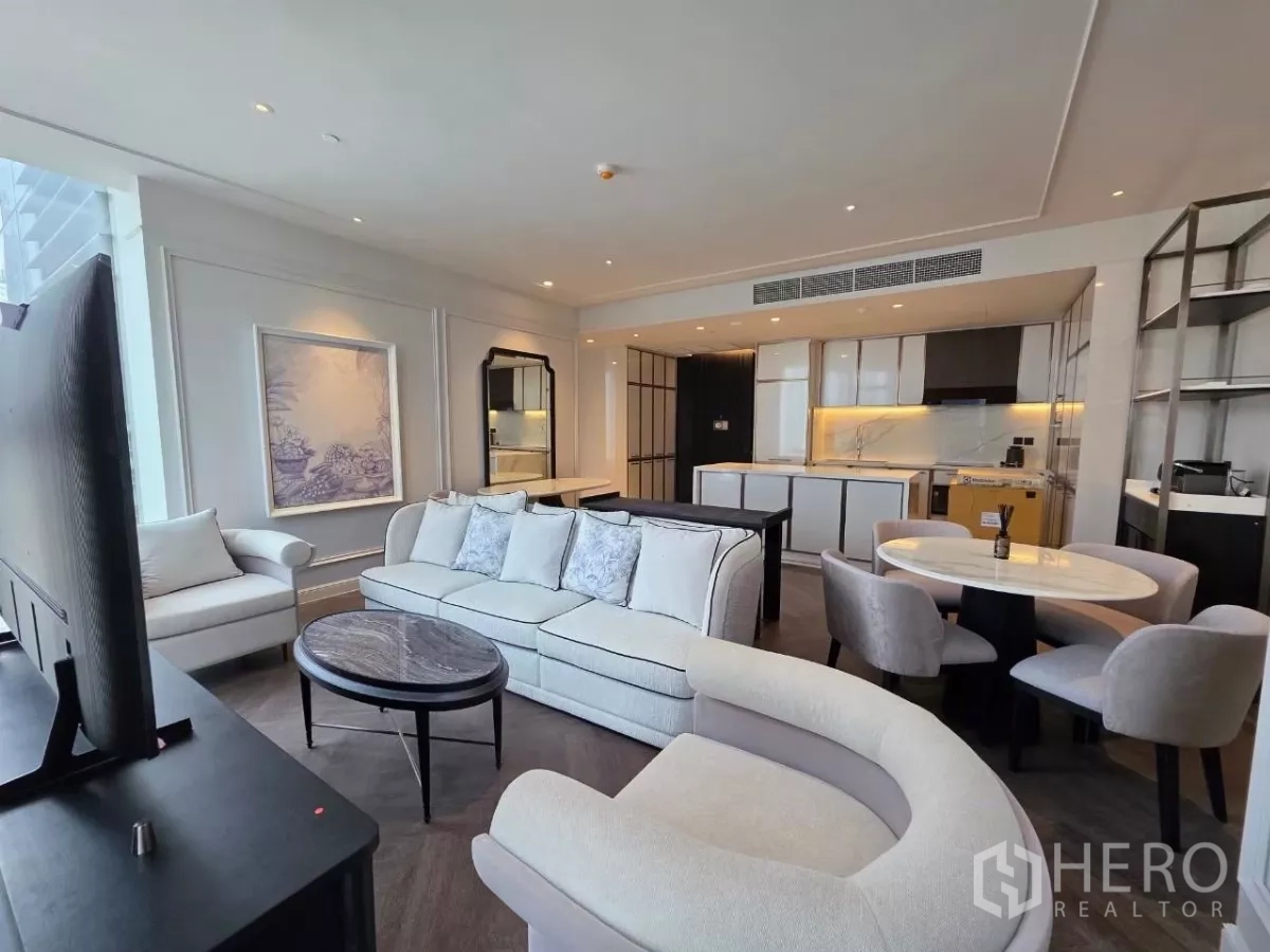 Condominium for rent - Open-plan living and dining area with built-in modern kitchen and round table.