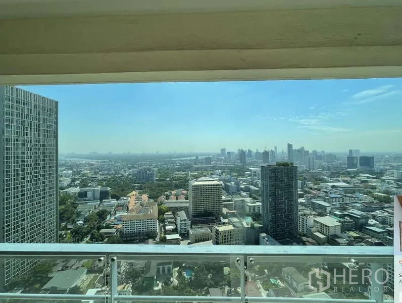 Condominium for rent - High-floor balcony view with panoramic Bangkok city skyline over Sathon.
