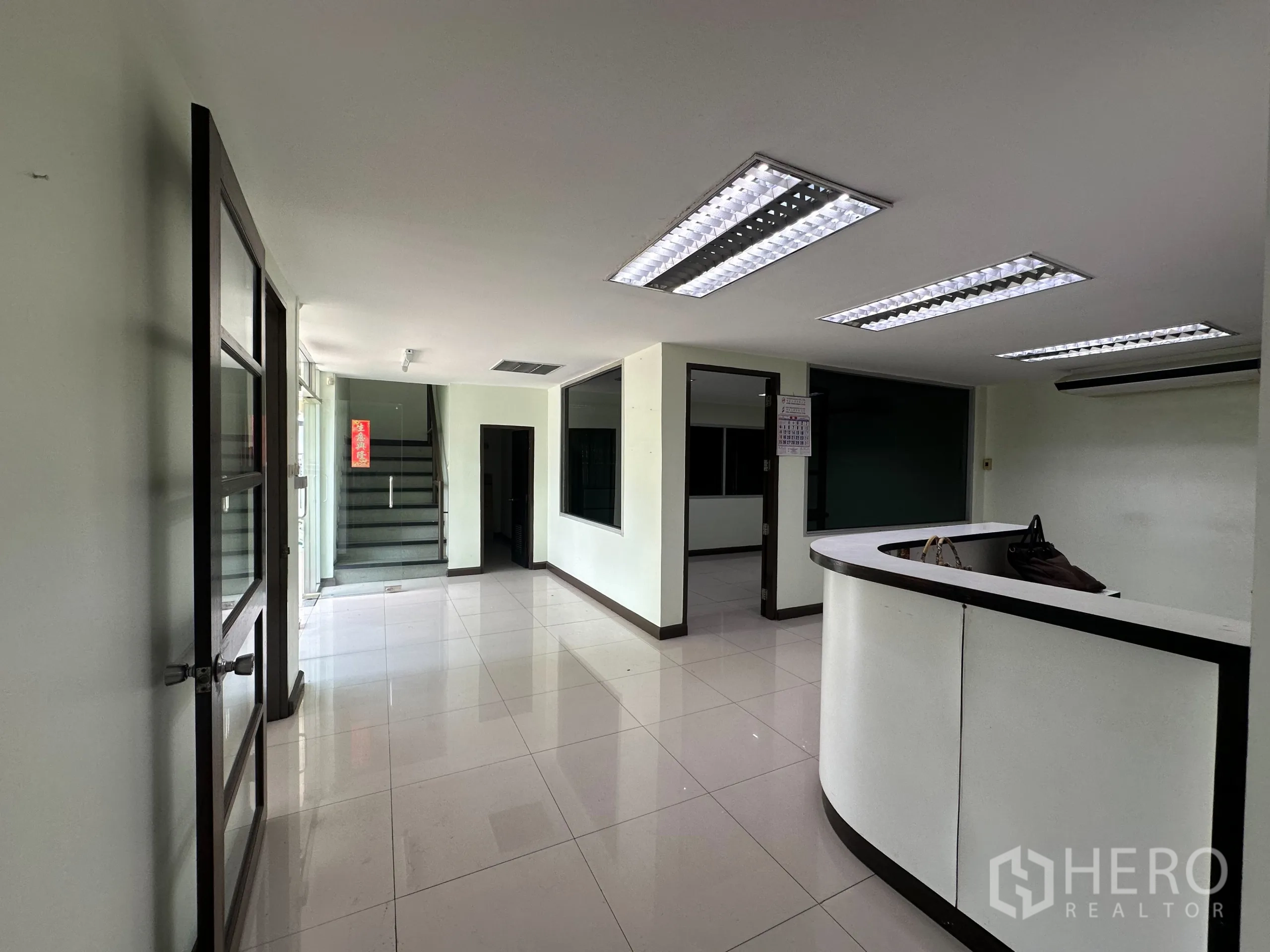 Retail Space for rent in Watthana, Bangkok - Ground-floor reception with curved counter and staircase to upper level.