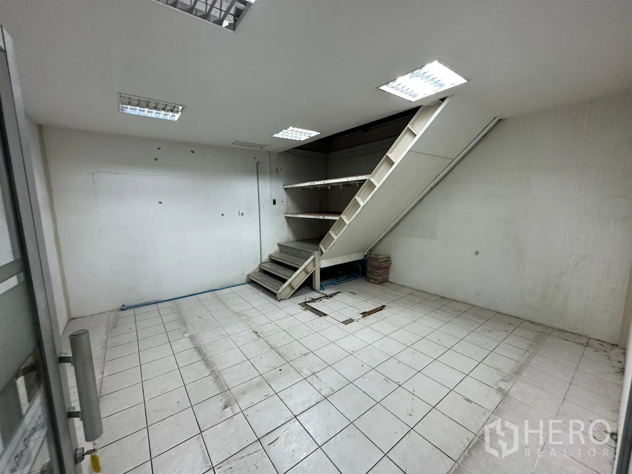 货栈 出租在Huai Khwang, Bangkok - 铺瓷砖的小型储物间，楼梯通往夹层。