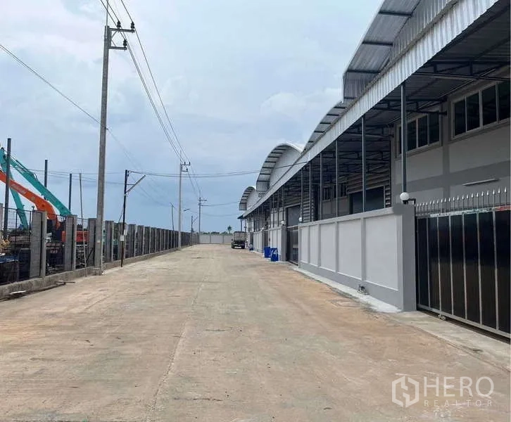 คลังสินค้า ให้เช่าในKrathum Baen, Samut Sakhon - โกดังสมัยใหม่หลังคาโค้งเรียงแนว ถนนคอนกรีตกว้าง พร้อมรั้วรอบขอบชิด ในอำเภอกระทุ่มแบน