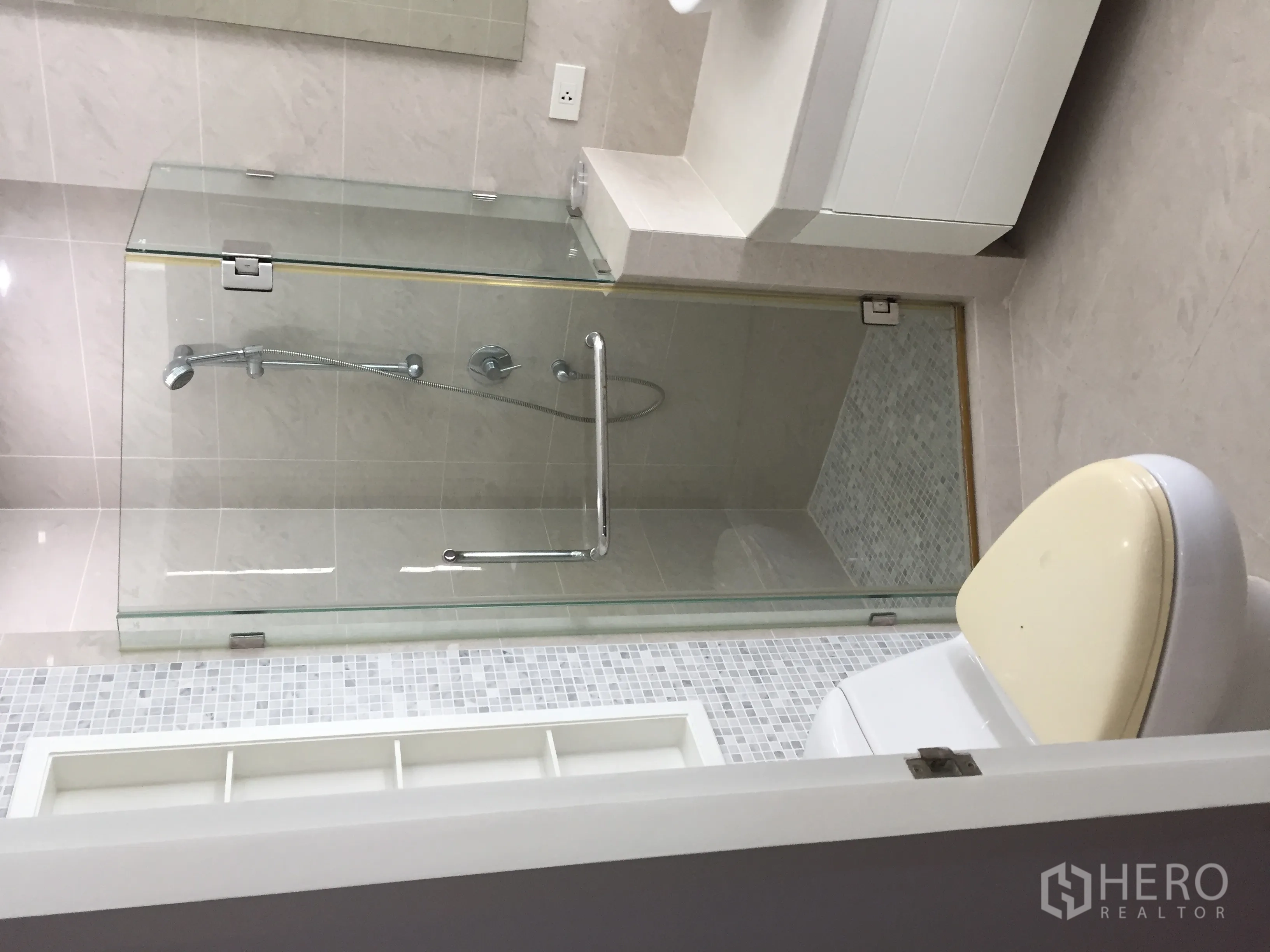 Condominium for rent in Khlong Toei, Bangkok - Modern bathroom featuring a glass-enclosed shower with handheld spray and sleek vanity.