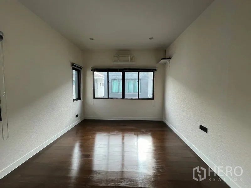 บ้าน ให้เช่าในBang Kapi, Bangkok - ห้องเอนกประสงค์โล่งพื้นไม้สีเข้มและหน้าต่างรอบด้าน