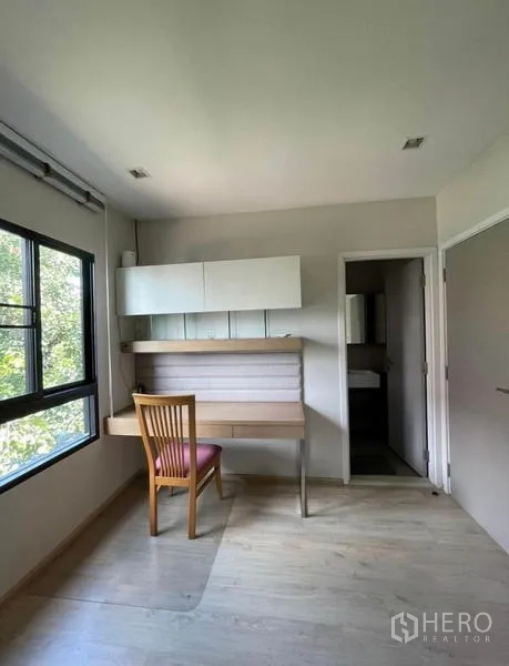 Townhouse for rent in Yan Nawa, Bangkok - Compact study or guest room with built-in desk, overhead cabinets, and window view to greenery.
