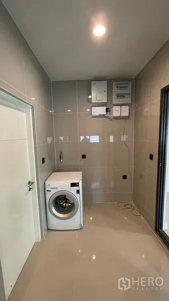 Detached House for rent in Bang Kapi, Bangkok - Utility and laundry room with washing machine, tiled walls and control panels.