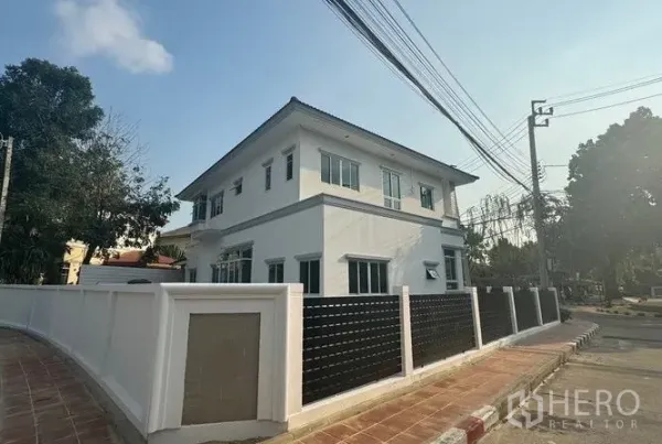 独立式住宅 出售在Pak Kret, Nonthaburi - 房屋侧后立面，实体围墙与多扇窗户