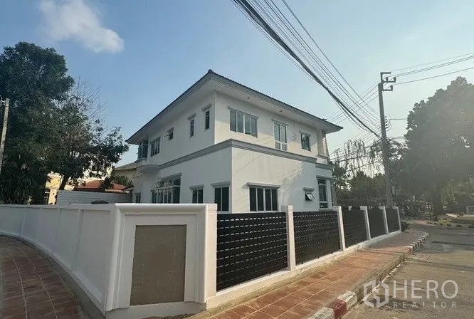 独立式住宅 出售在Pak Kret, Nonthaburi - 房屋侧后立面，实体围墙与多扇窗户