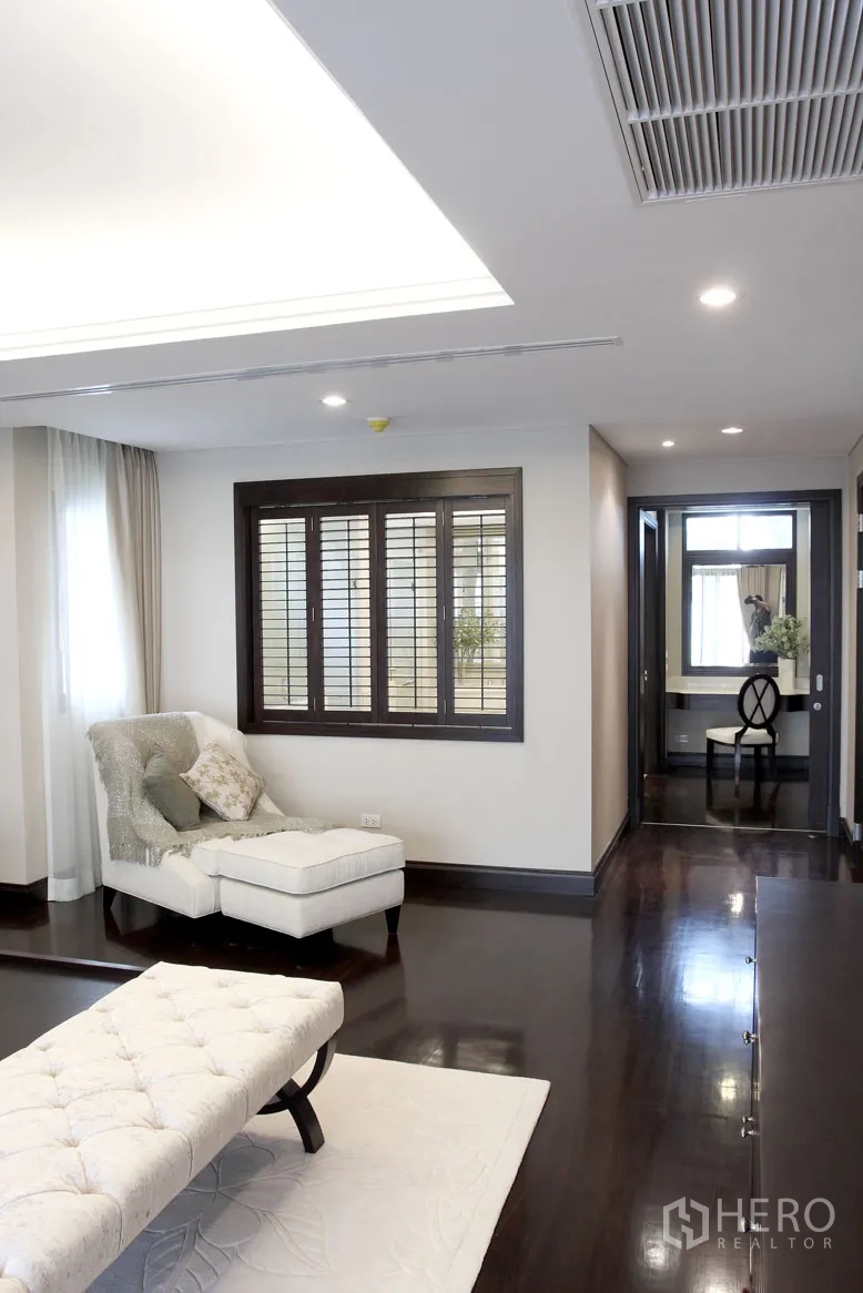 Detached House for rent in Khlong Toei, Bangkok - Upstairs sitting area with chaise lounge, dark wood floors and shuttered windows.