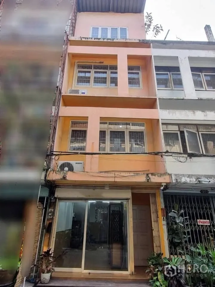Shophouse for rent in Phra Khanong, Bangkok - Multi-storey shophouse exterior with glass entrance and upper windows.