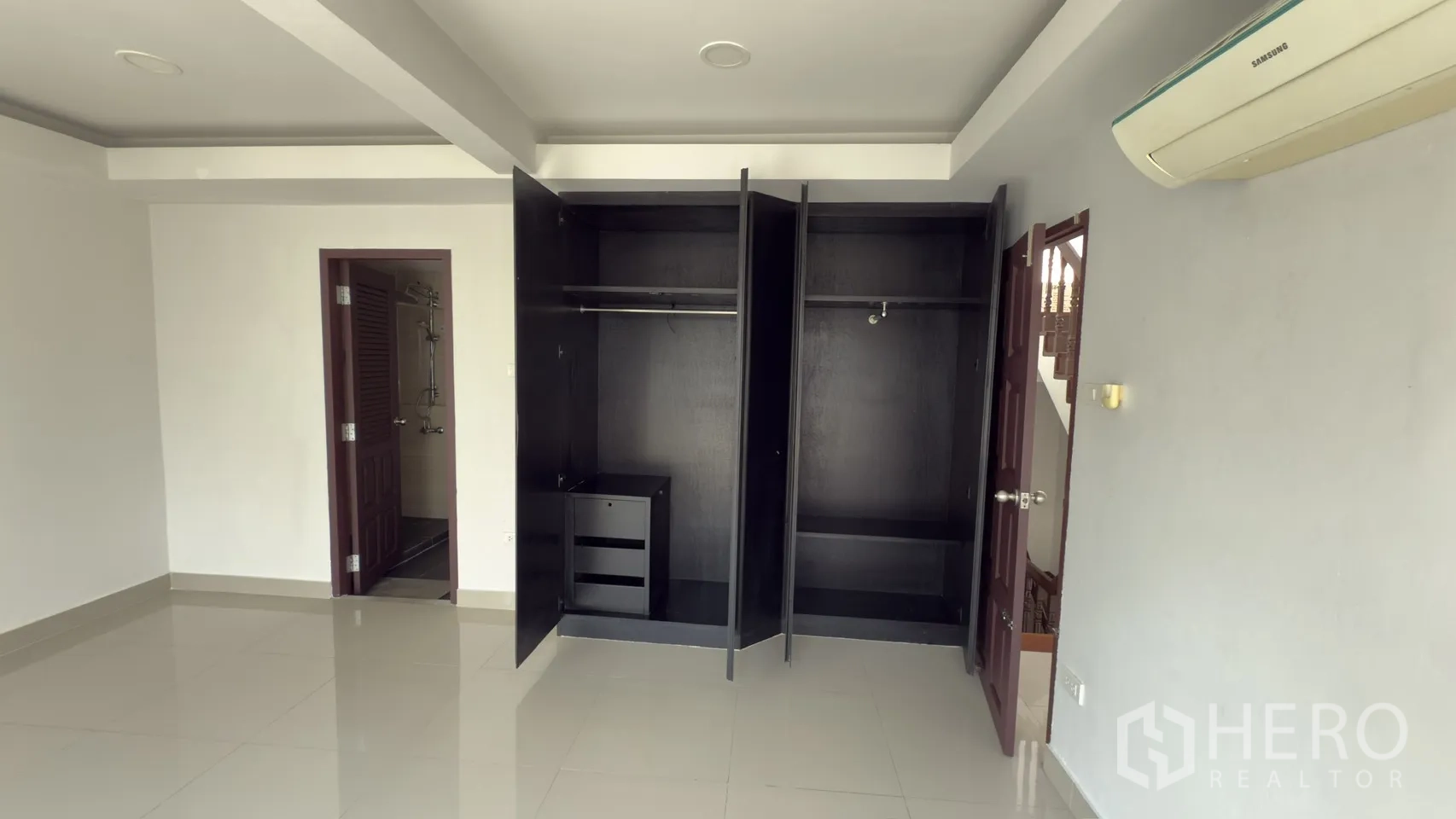 联排别墅 for rent in Watthana, Bangkok - 宽敞卧室，两个打开的衣柜，亮面地砖与套卫入口。