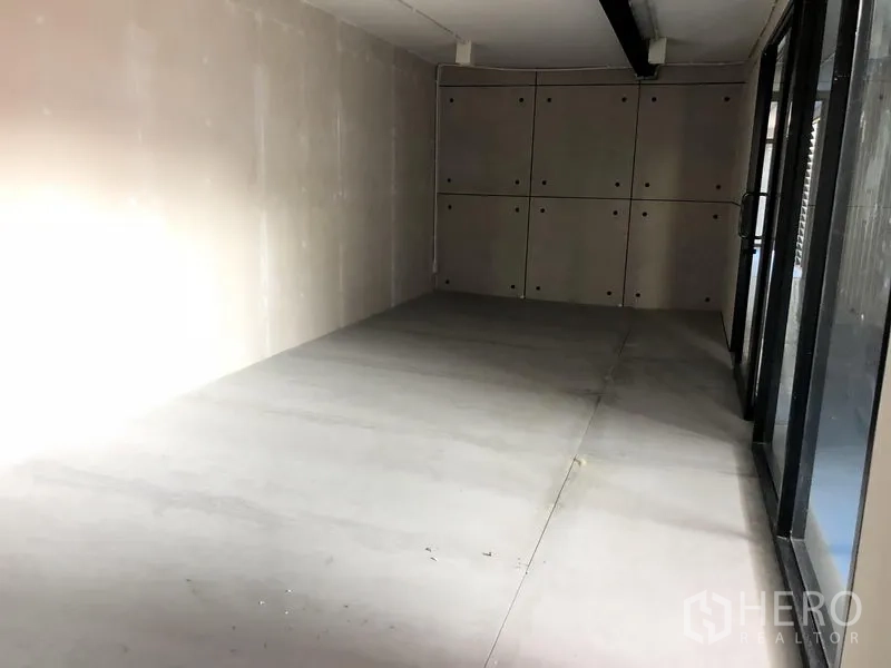 办公空间 出租在Khlong Toei, Bangkok - 现代办公室内的小型房间，石膏板墙、水泥地面与落地玻璃。