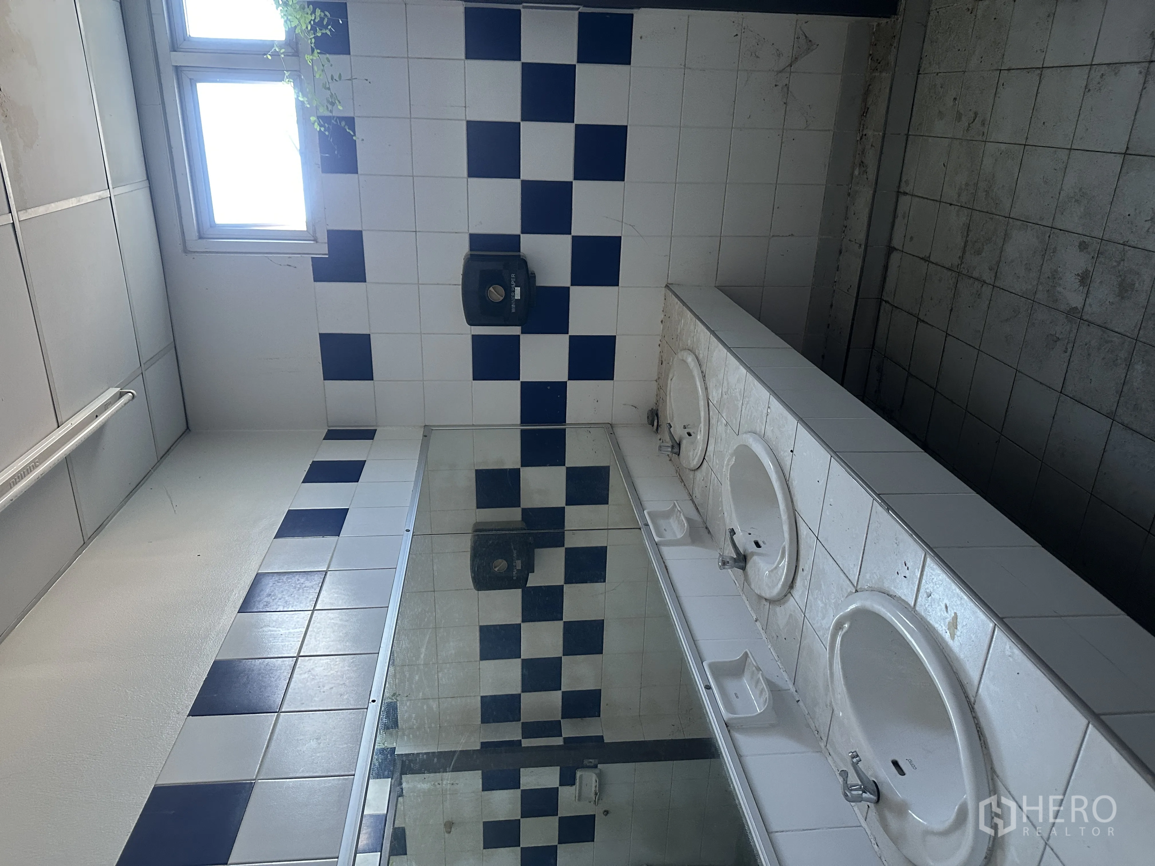 โรงงาน for rent in Bang Pa-in, Phra Nakhon Si Ayutthaya - ห้องน้ำผนังกระเบื้องลายสีน้ำเงิน‑ขาว กระจกยาว และอ่างล้างมือหลายจุด
