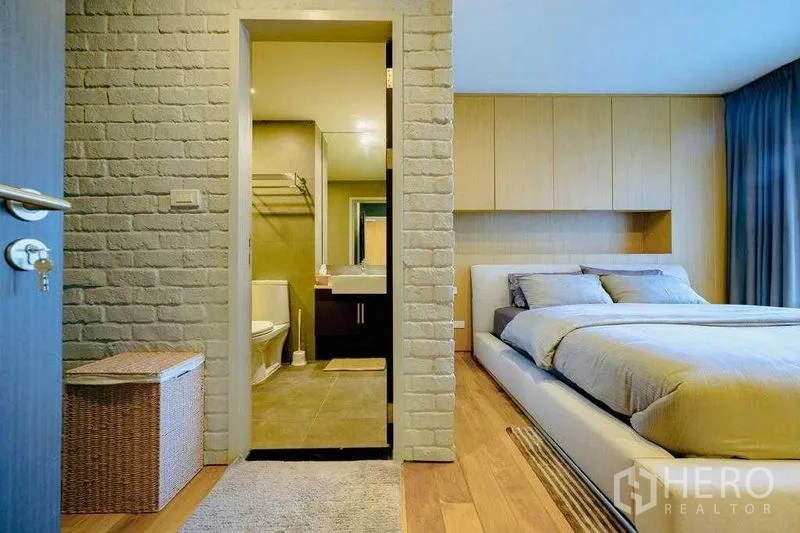 Condominium for rent in Watthana, Bangkok - Ensuite layout showing doorway from bedroom to tiled bathroom with mirrored vanity.