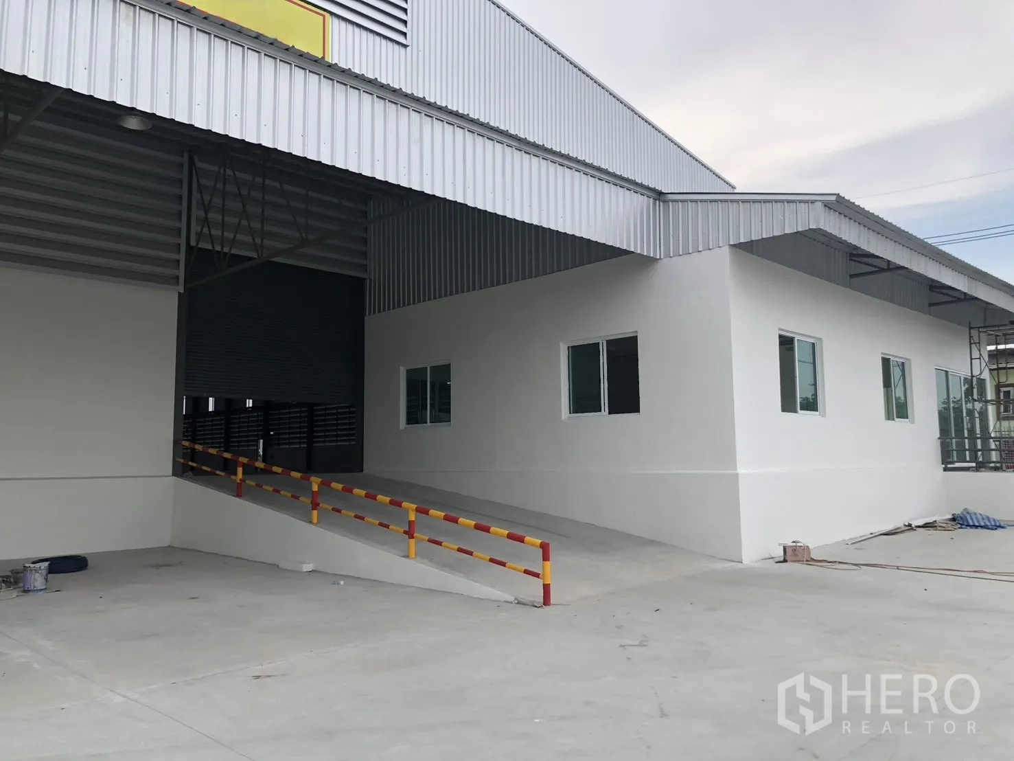 工厂 for rent in Si Racha, Chon Buri - 带雨棚的装卸坡道及侧面办公室立面与窗户。