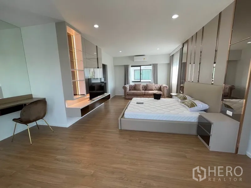 独立式住宅 出租在Prawet, Bangkok - 主卧套间一角，电视墙、沙发角与木地板